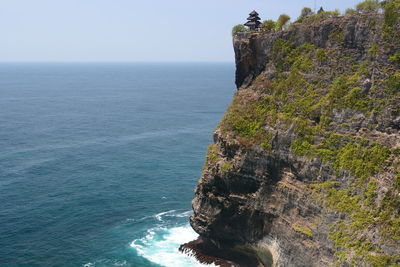 Rock formation by sea against sky