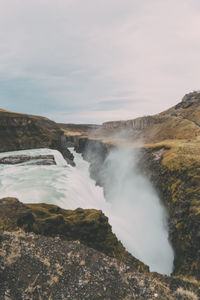 Scenic view of waterfall against sky