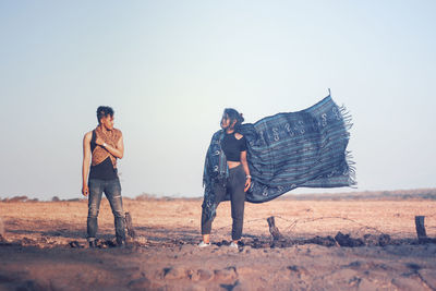 People standing on field against clear sky