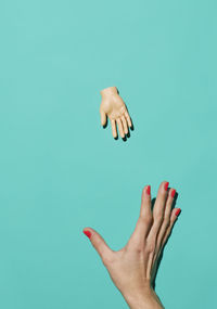 Close-up of hand over blue background