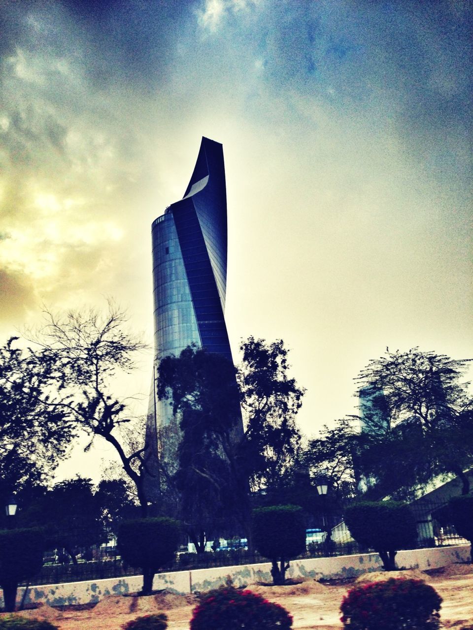 built structure, architecture, sky, tree, building exterior, low angle view, cloud - sky, famous place, travel destinations, tall - high, cloud, tower, tourism, travel, history, monument, international landmark, city, architectural column, modern