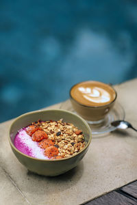 Cup of coffee and bowl of pitaya muesli