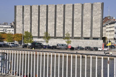 City street by modern buildings against sky