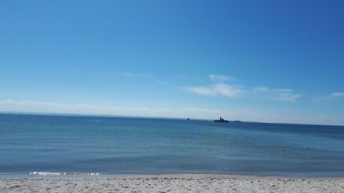 Scenic view of sea against blue sky