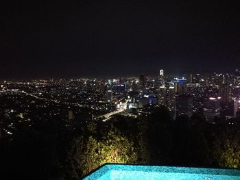 Illuminated cityscape against sky at night