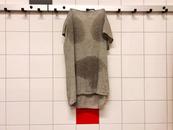 T-shirt hanging from tiled wall