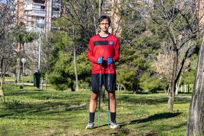 Nordic walking. young person practicing the sport nordic walking with poles in an outdoor park. 