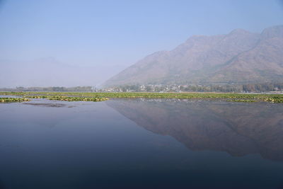 Scenic view of lake by mountains against sky