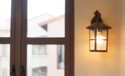 Close-up of illuminated lamp on wall at home