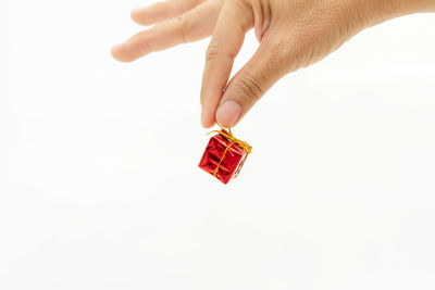 Close-up of hand holding toy over white background