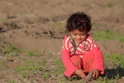 A beautiful indian child destroying weeds in the field, young child farmer ,concept for agriculture