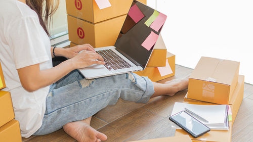 Midsection of woman using laptop on table