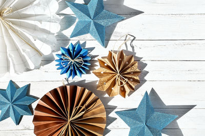 Winter holiday decoration. paper snowflakes, paper blue stars and fans made of craf paper