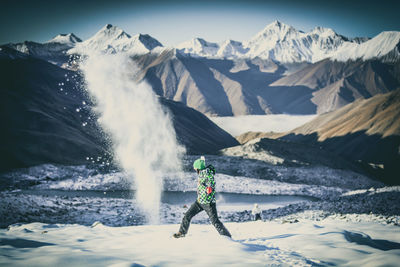 Woman standing on snowcapped mountain