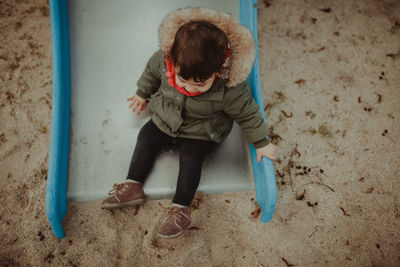 High angle view of girl playing on slide