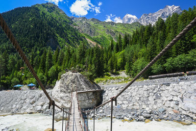 Suspension bridge with mountains in the background.