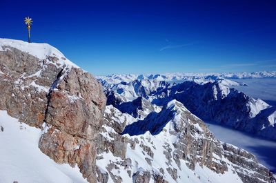 Scenic view of snowcapped mountains against clear blue sky