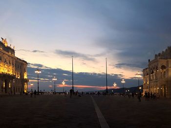 Group of people on street in city at sunset