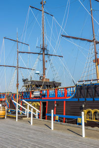 Sailboats moored in sea against clear blue sky