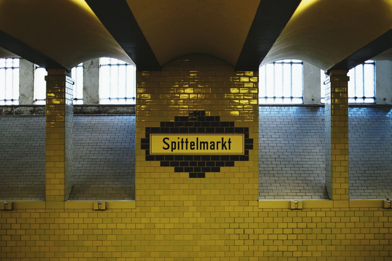 text, western script, indoors, communication, architecture, built structure, illuminated, information sign, subway station, non-western script, railroad station, yellow, transportation, public transportation, capital letter, sign, information, no people, empty, subway