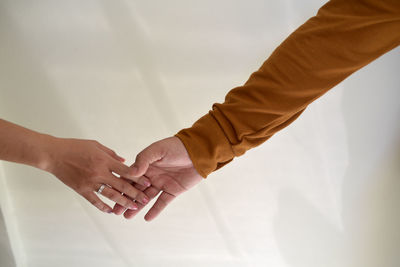 Midsection of couple holding hands