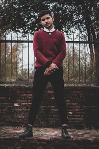 Portrait of young man standing against trees