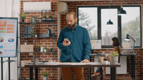 Businessman using phone at home