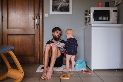 Side view of young man sitting at home