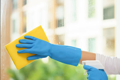 Cropped hand cleaning glass window