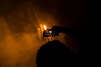 Close-up of hand holding lit candle