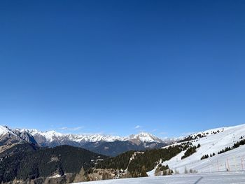 Scenic view of snowcapped mountains against clear blue sky