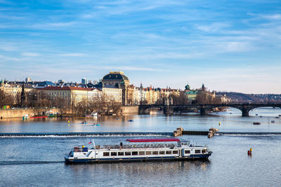 Boats in river against buildings in city