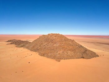 Scenic view of desert against clear blue sky