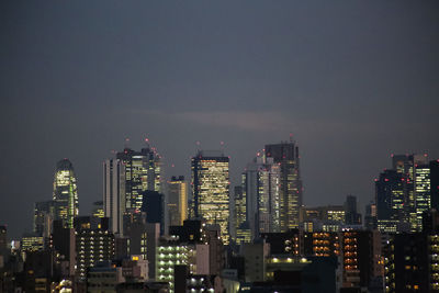 Illuminated cityscape against sky at night