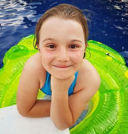 Portrait of smiling girl with inflatable ring in swimming pool