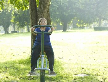 Full length of man on tree trunk in park