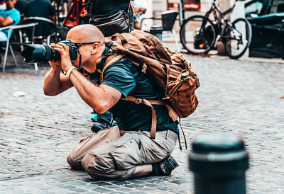 Man looking at camera while sitting on street