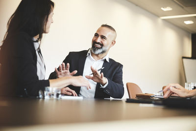 Male and female lawyers discussing at conference table in board room