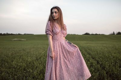 Woman standing on field against sky