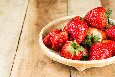 High angle view of strawberries in basket on table