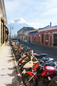 Cars parked on street in city against sky