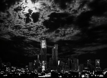 Low angle view of modern skyscraper against cloudy sky