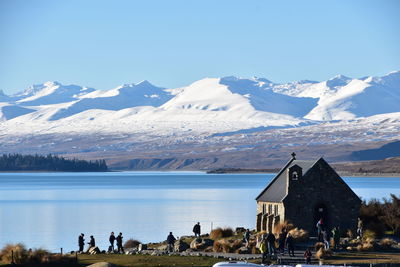 Scenic view of lake by snowcapped mountains against sky