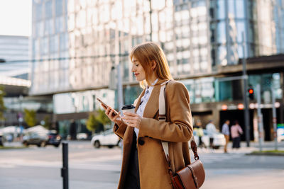 Young woman using mobile phone in city