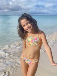 Young hispanic girl standing at beach