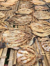 Fishes drying on wooden plank