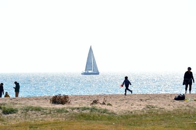 Man standing on beach against clear sky