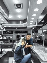 Full length of man looking at illuminated store