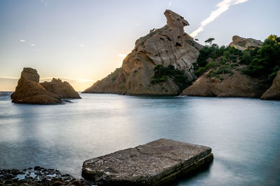 Rock formations in sea against sky