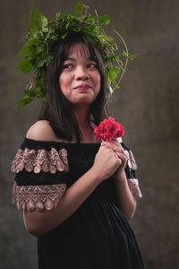 Portrait of a beautiful young woman standing against white wall